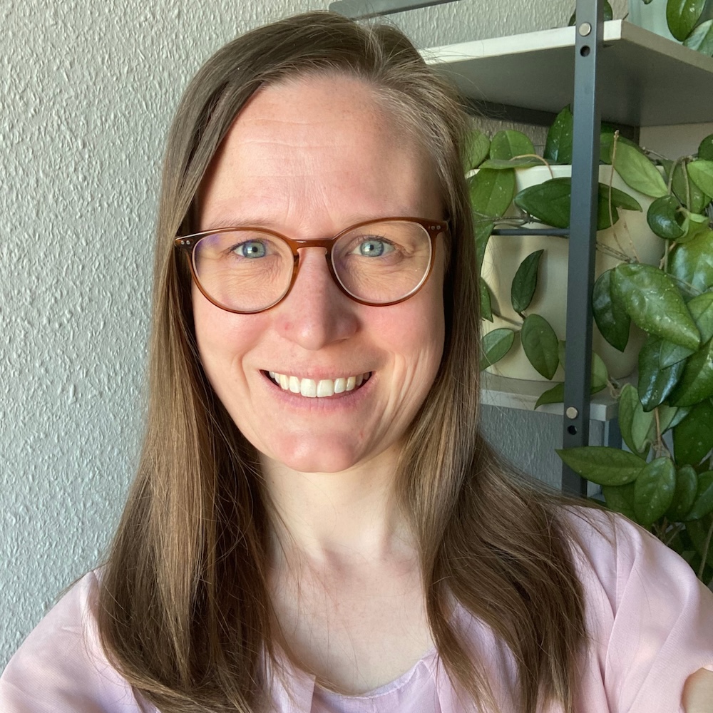 Portrait von Annemarie, Teilnehmerin des Online-Programms Mit Klarheit in deine berufliche Zukunft. Sie trägt eine Brille und ein rosa Oberteil.