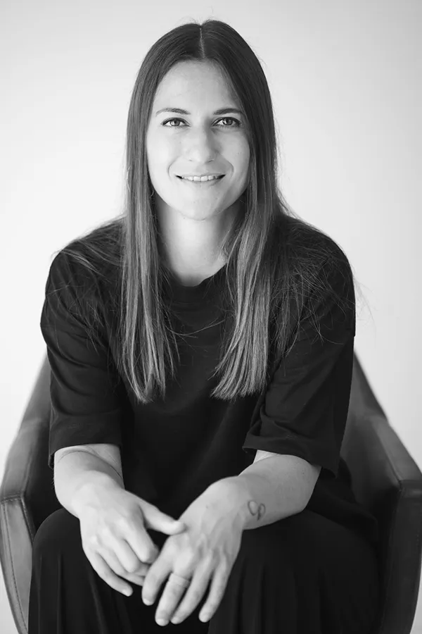 Giulia Barile, DGSv-zertifizierte systemische Supervisorin in Köln und Coach für berufliche Neuorientierung, sitzt auf einem braunen Stuhl und schaut in die Kamera, sitzt auf einem braunen Stuhl und schaut in die Kamera
