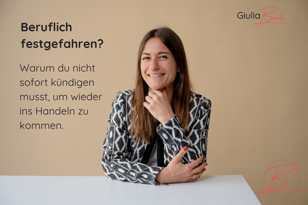 Supervisorin und Coach Giulia Barile sitzt an einem weißen Schreibtisch mit beigen Hintergrund. In der oberen linken Ecke der Schriftzug: Berufliche festgefahren? Warum du nicht sofort kündigen musst, um wieder ins Handeln zu kommen.